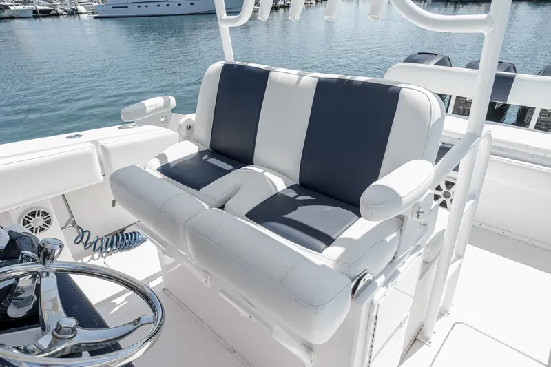Slide: The Image of 2019 Fountain 38 CC boat interior with dual-tone seating and steering wheel, docked at marina. - 23