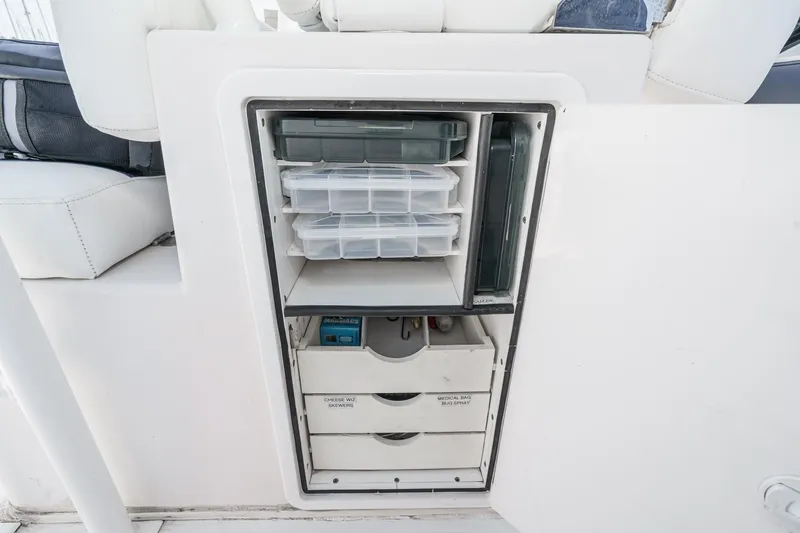 Slide: The Image of Storage compartment on a 2019 Fountain 38 CC boat with organized containers and drawers. - 24