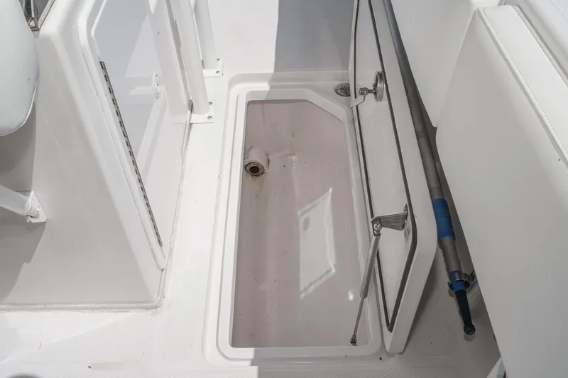 Slide: The Image of Open storage compartment on 2019 Fountain 38 CC boat, showcasing interior space and drainage. - 32