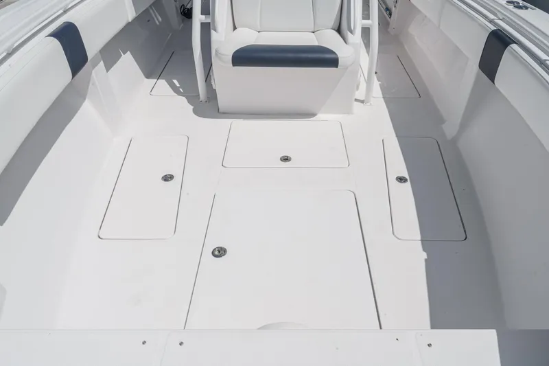 Slide: The Image of 2019 Fountain 38 CC boat interior with white seating and storage compartments. - 38