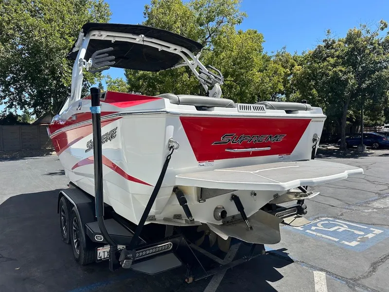 Slide: The Image of 2021 Supreme ZS212 boat with red and white design, parked outdoors. - 10