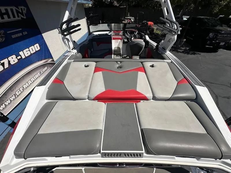 Slide: The Image of 2021 Supreme ZS212 boat interior with gray and red seating, docked outdoors. - 11
