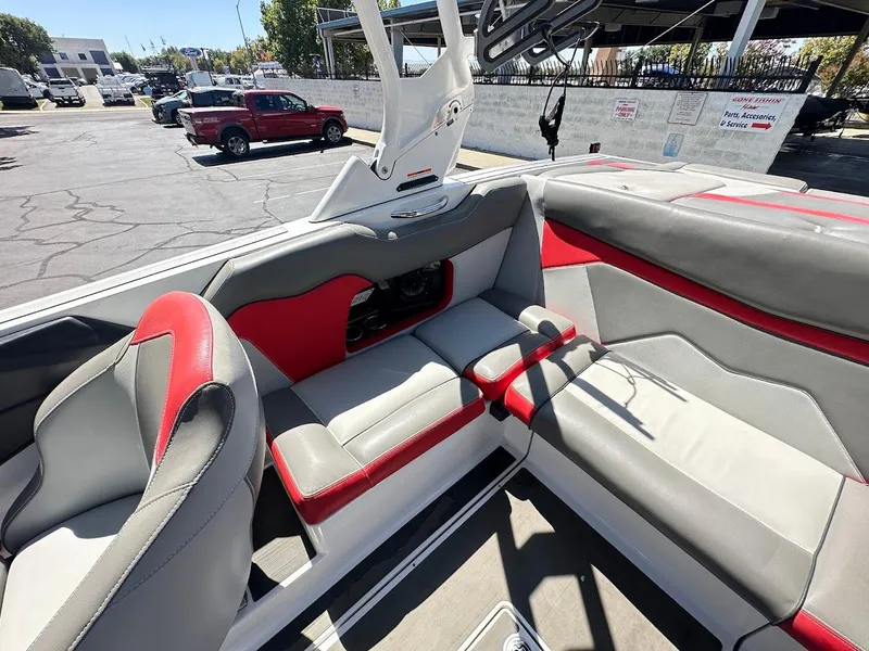 Slide: The Image of 2021 Supreme ZS212 boat interior with red and gray seating, parked outdoors. - 14