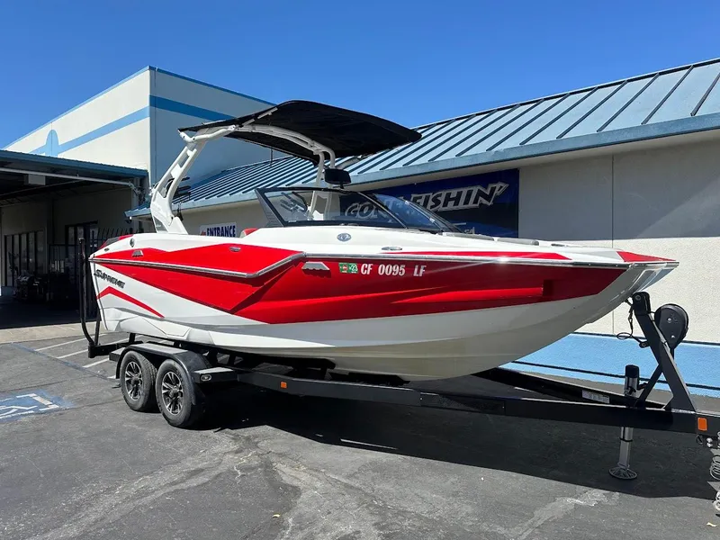 Slide: The Image of 2021 Supreme ZS212 boat in red and white on a trailer outside a building. - 2