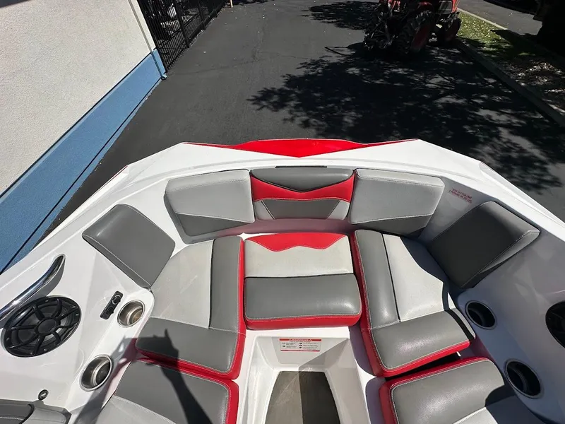 Slide: The Image of 2021 Supreme ZS212 boat interior with red and gray seating, cup holders, and speaker. - 25
