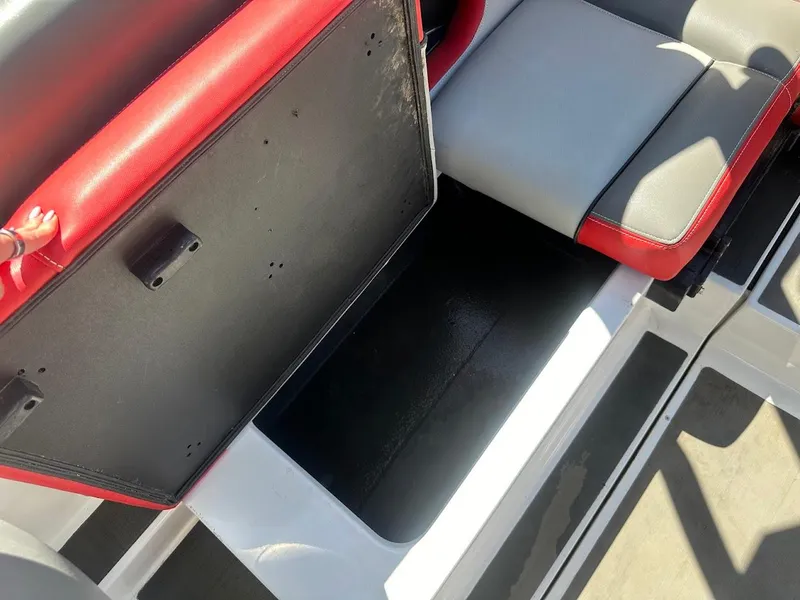 Slide: The Image of Open storage compartment in 2021 Supreme ZS212 boat with red and gray seating. - 32