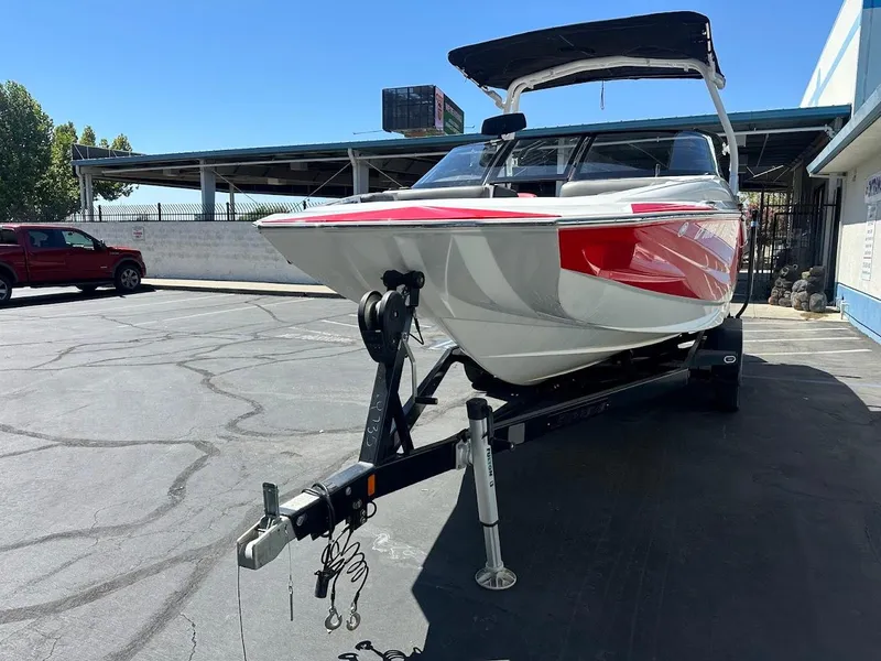 Slide: The Image of 2021 Supreme ZS212 boat on trailer in parking lot, featuring red and white design. - 4