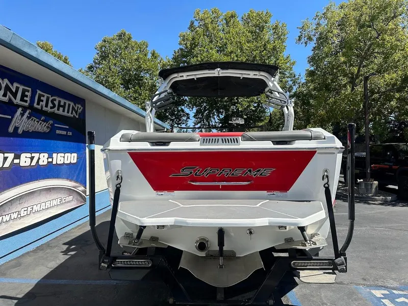 Slide: The Image of 2021 Supreme ZS212 boat with red and white design, parked outdoors. - 9