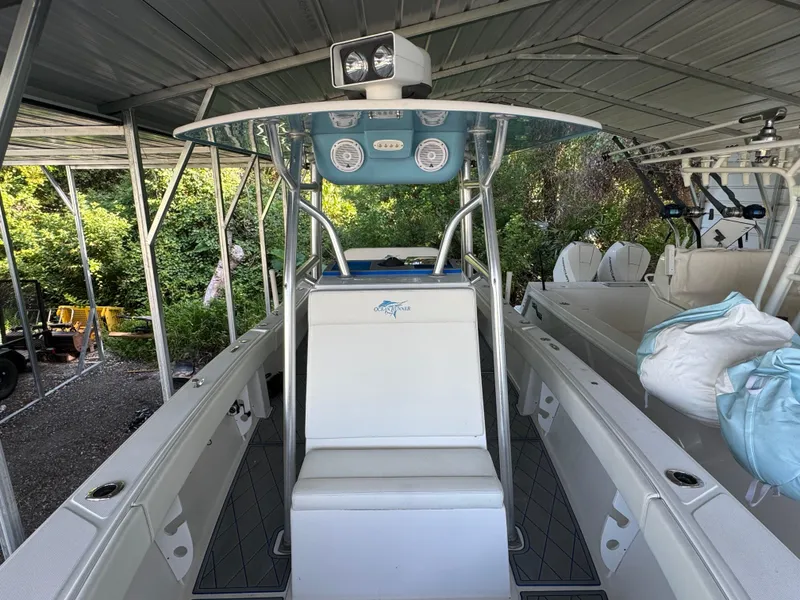 Slide: The Image of 2012 Ocean Runner 290i boat under a metal canopy, featuring a central console and seating. - 11