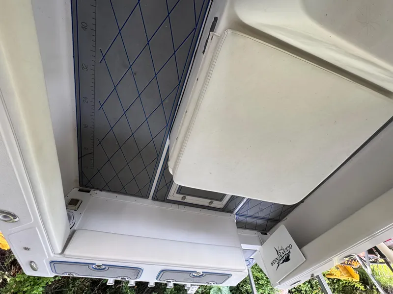 Slide: The Image of Interior view of a 2012 Ocean Runner 290i boat, featuring storage compartments and a measuring board. - 22