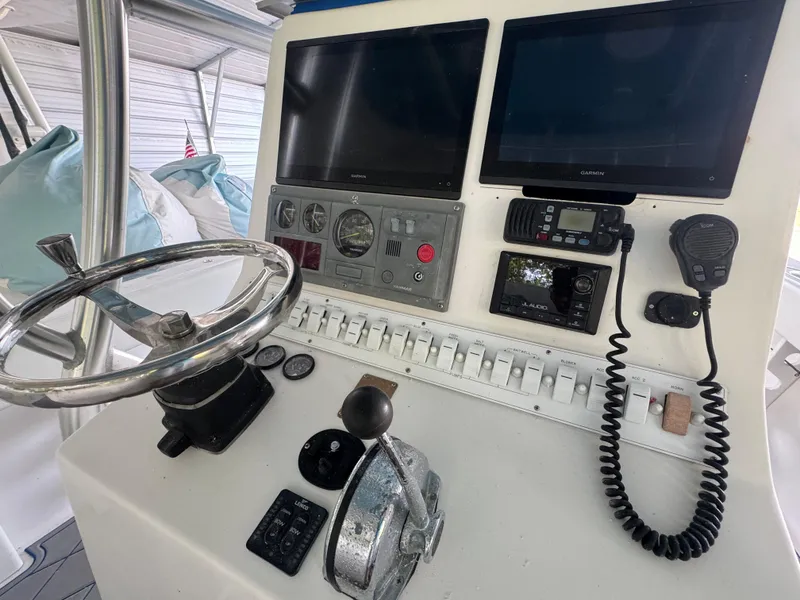 Slide: The Image of Control panel of a 2012 Ocean Runner 290i boat with steering wheel and navigation equipment. - 26
