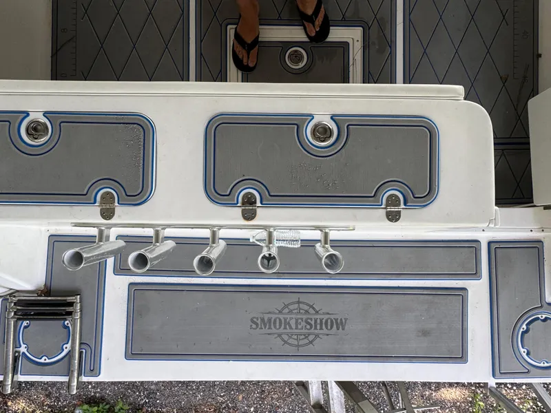 Slide: The Image of 2012 Ocean Runner 290i boat deck with rod holders and 'SMOKESHOW' branding. - 9