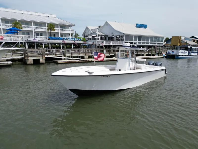 Slide: The Image of 2009 Contender 35 ST boat docked near waterfront buildings with American flag. - 2