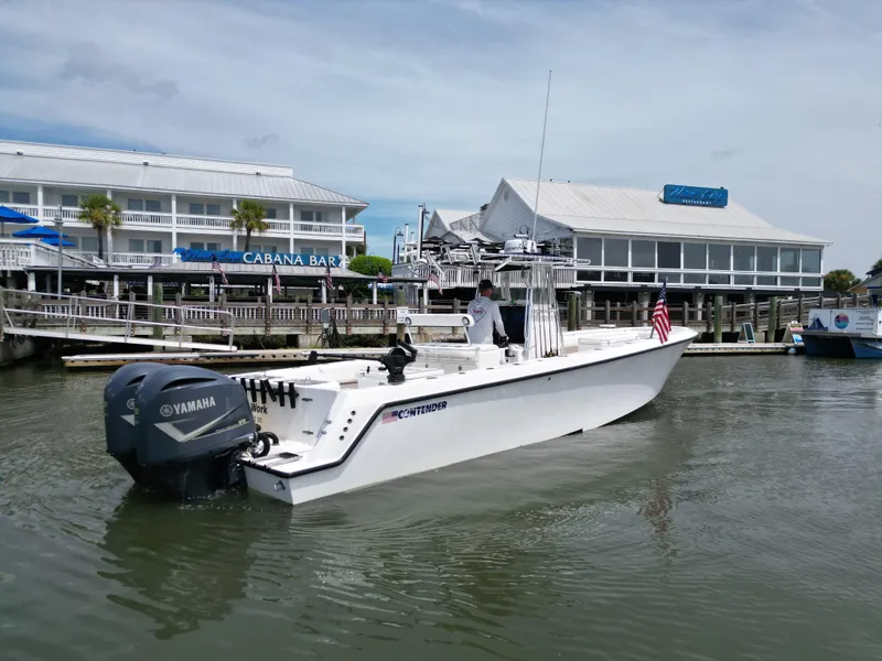 Slide: The Image of 2009 Contender 35 ST boat with Yamaha engine near waterfront restaurant. - 3