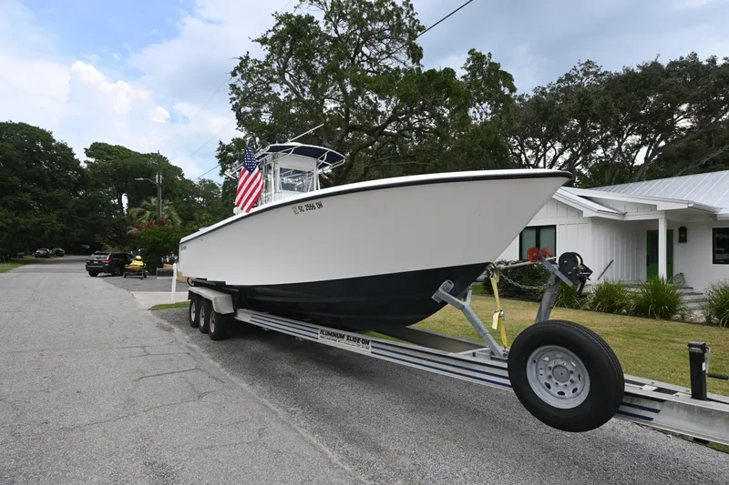 Slide: The Image of 2009 Contender 35 ST boat on trailer, parked in residential area with American flag. - 5