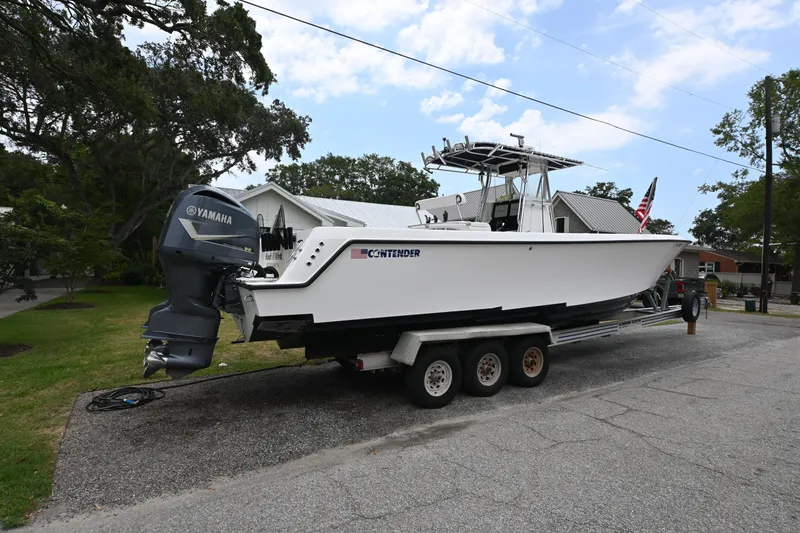Slide: The Image of 2009 Contender 35 ST boat on trailer with Yamaha engine, parked in residential area. - 6