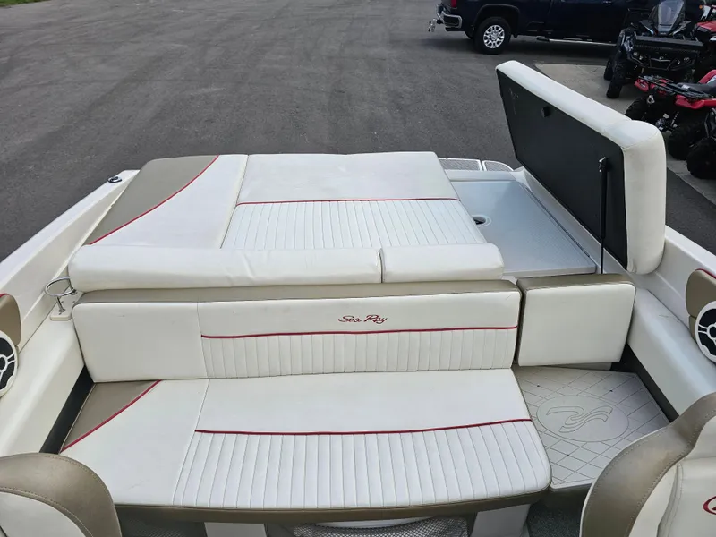 Slide: The Image of 2007 Sea Ray 210 Select boat interior with white and beige seating, open storage compartment. - 12