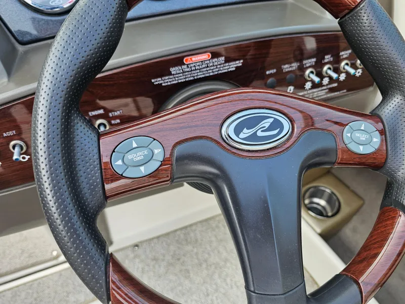 Slide: The Image of Steering wheel of a 2007 Sea Ray 210 Select boat with wood accents and controls. - 17