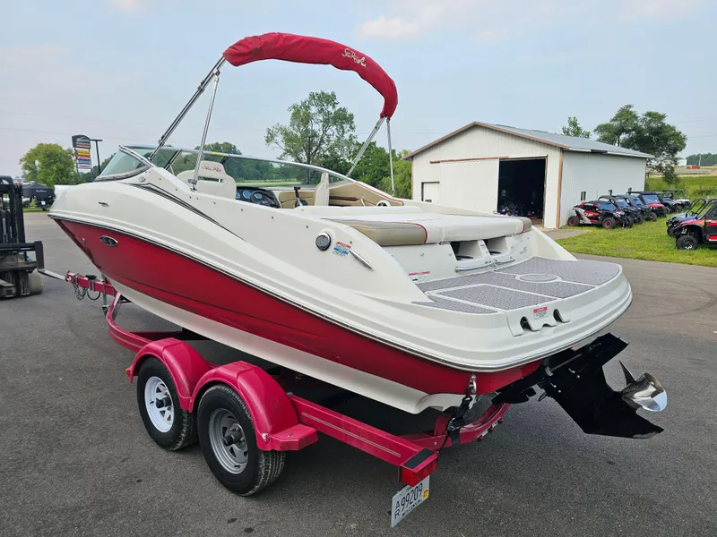 Slide: The Image of 2007 Sea Ray 210 Select boat on trailer, red and white design, parked outdoors. - 4