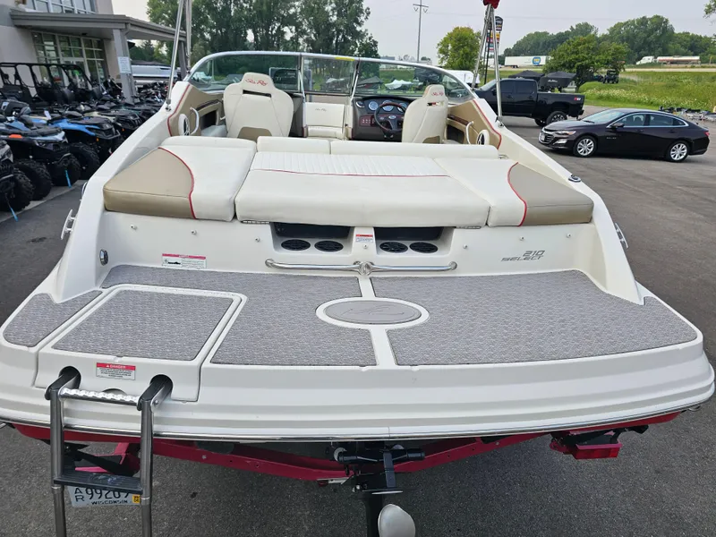 Slide: The Image of 2007 Sea Ray 210 Select boat with beige seating and swim platform, parked outdoors. - 8