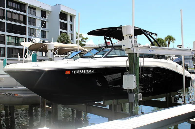Slide: The Image of 2023 Sea Ray SPX 230 Outboard boat docked at marina, black hull, modern design. - 0