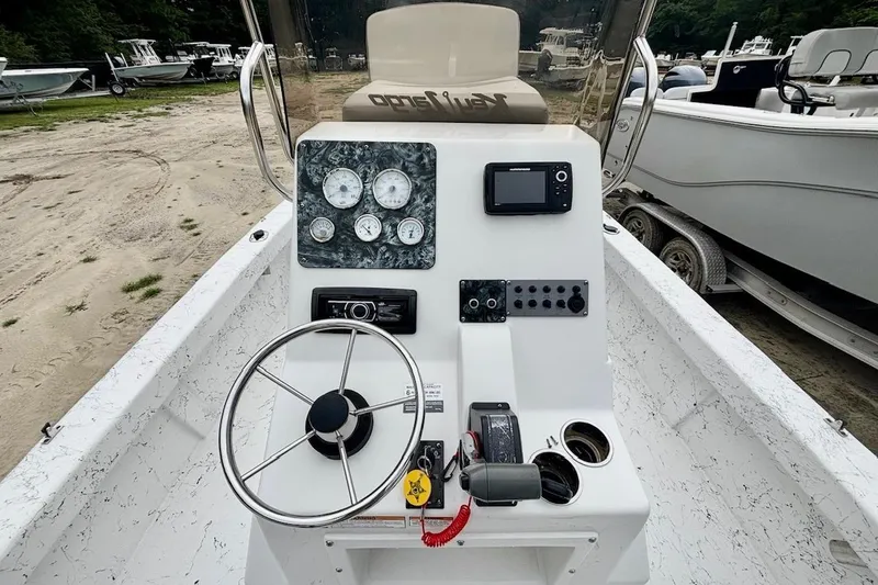 Slide: The Image of 2019 Key Largo 206 Bay boat dashboard with steering wheel and control panel. - 4