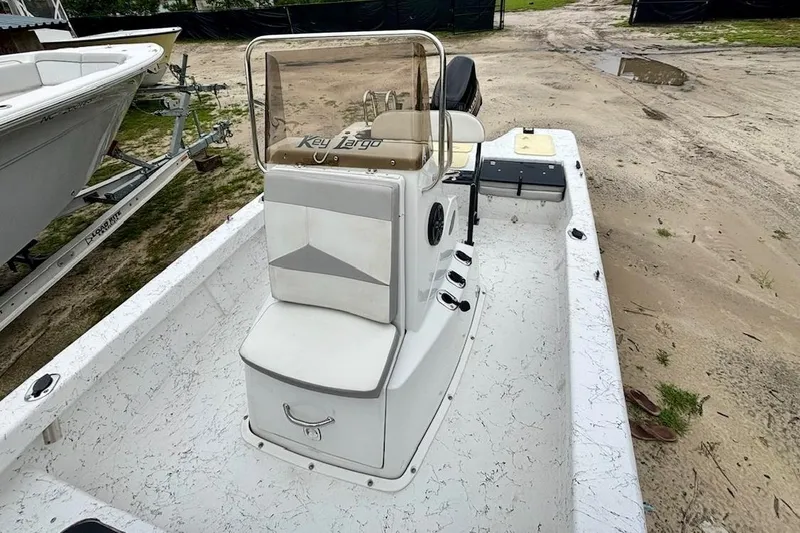 Slide: The Image of 2019 Key Largo 206 Bay boat on sandy terrain, featuring a central console and seating. - 5