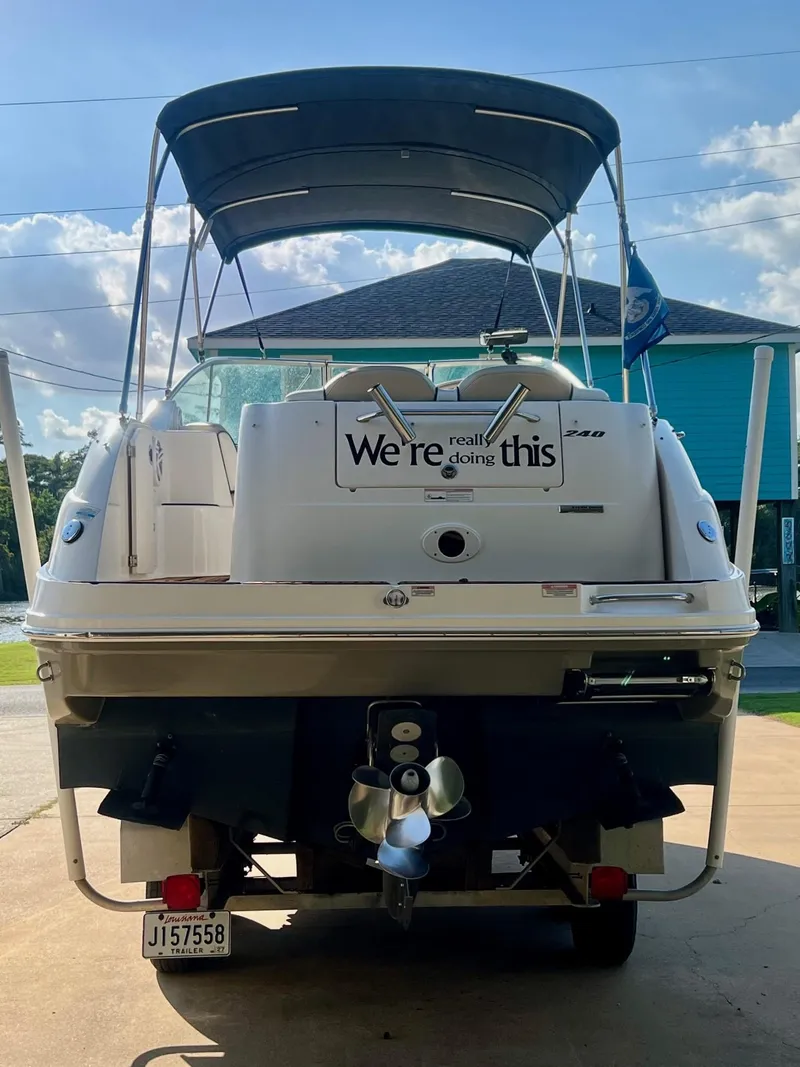 Slide: The Image of 2009 Sea Ray 240 Sundancer boat with canopy and humorous sign on the back. - 2