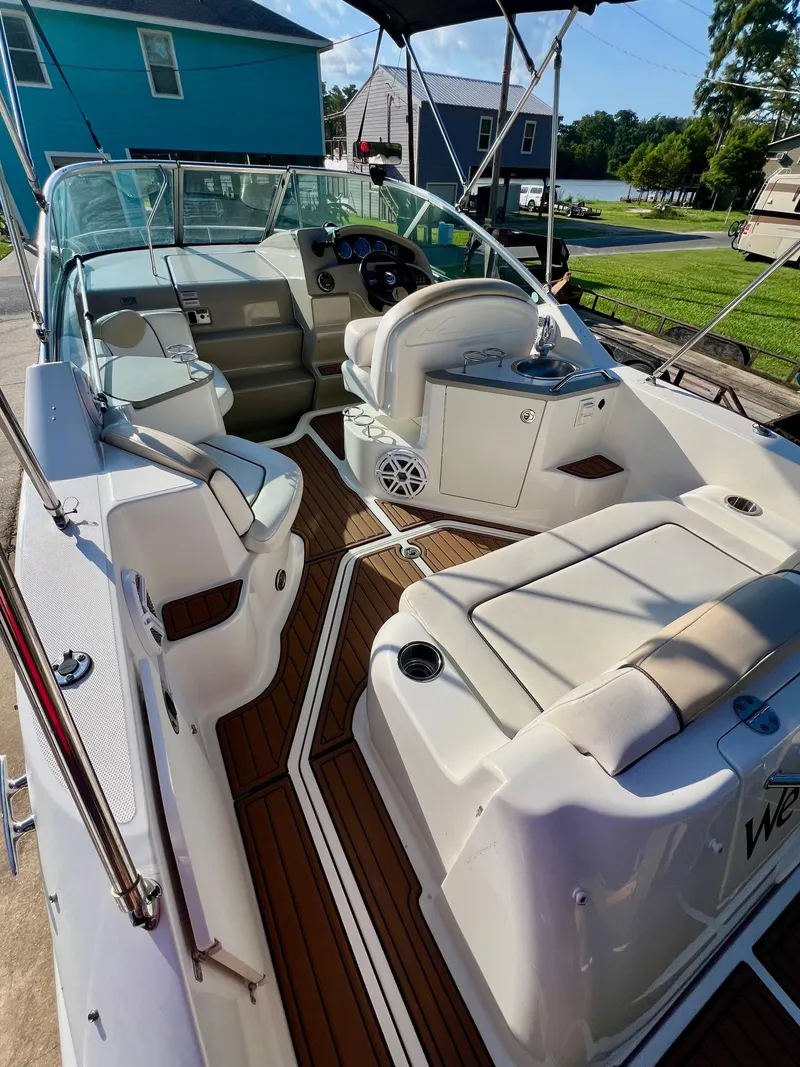 Slide: The Image of 2009 Sea Ray 240 Sundancer boat interior with seating, steering wheel, and wood accents. - 6