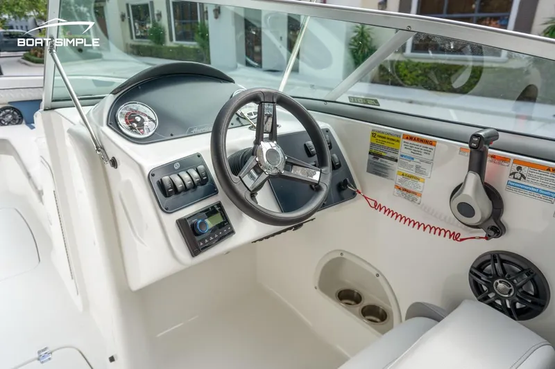 Slide: The Image of 2025 Hurricane SunDeck 2400 OB boat dashboard with steering wheel and controls. - 12