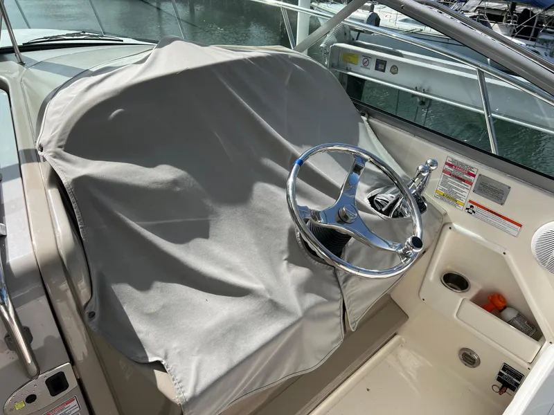 Slide: The Image of 2008 Sea Ray 290 Amberjack boat with fishing rod holders, docked near palm trees and waterfront homes. - 15