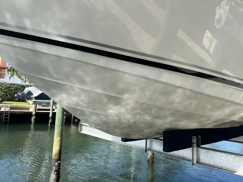 Slide: The Image of 2008 Sea Ray 290 Amberjack boat hull with blue stripe, docked above water. - 19