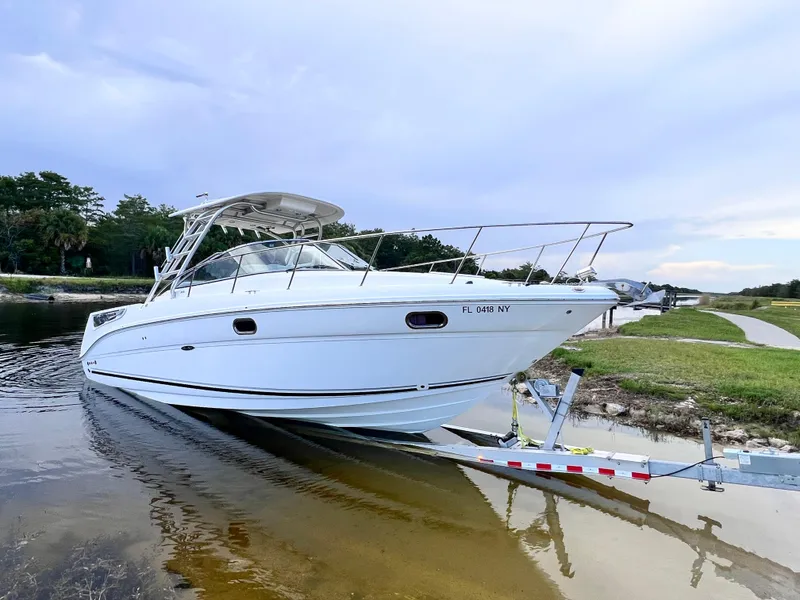 Slide: The Image of 2008 Sea Ray 290 Amberjack boat deck with seating, overlooking a scenic waterfront. - 4