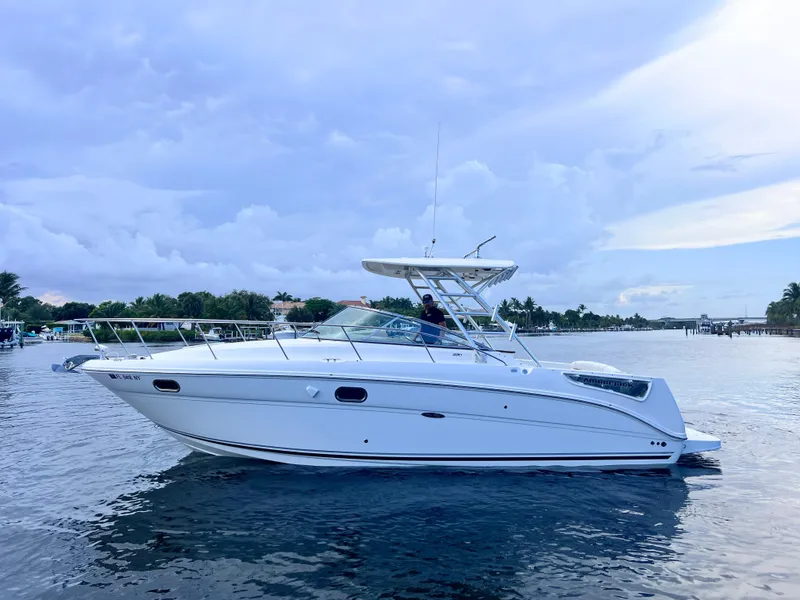 Slide: The Image of 2008 Sea Ray 290 Amberjack boat docked, showcasing sleek deck and windshield design. - 6