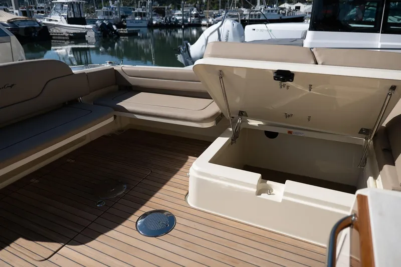 Slide: The Image of 2024 Chris-Craft Calypso 32 boat interior with open storage compartment and seating. - 17