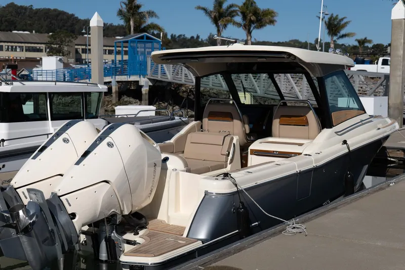Slide: The Image of 2024 Chris-Craft Calypso 32 boat docked, featuring dual outboard engines and elegant design. - 19