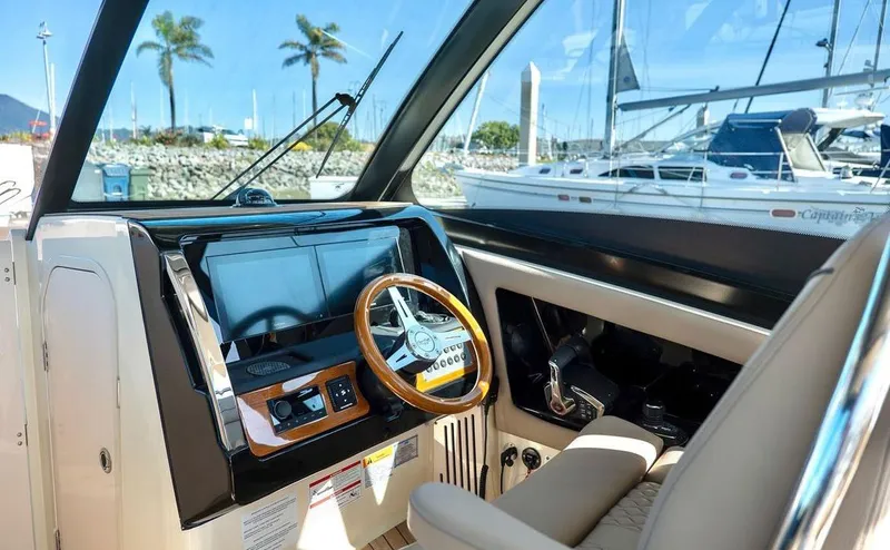 Slide: The Image of 2024 Chris-Craft Calypso 32 helm with modern controls and wooden steering wheel. - 2