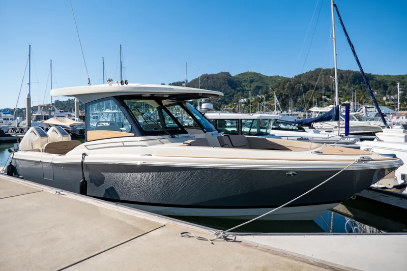 Slide: The Image of 2024 Chris-Craft Calypso 32 luxury boat docked at marina, clear blue sky. - 32