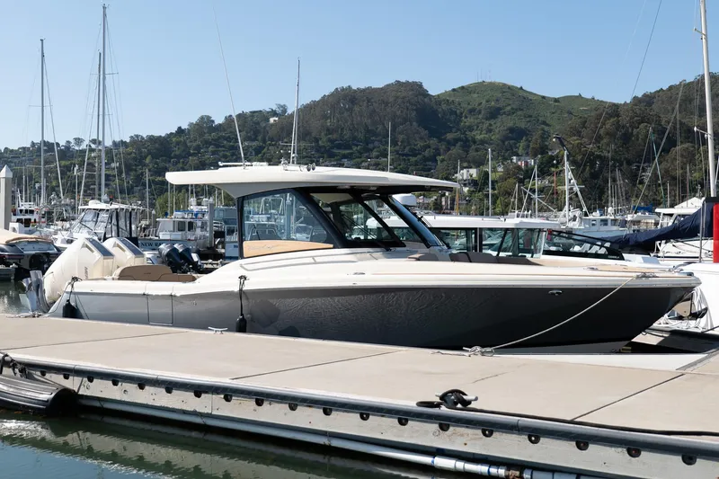 Slide: The Image of 2024 Chris-Craft Calypso 32 docked at a marina with scenic hillside backdrop. - 33