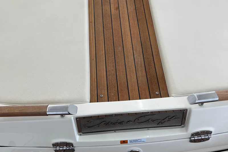 Slide: The Image of 2023 Chris-Craft Launch 27 boat deck with teak wood and white upholstery. - 14