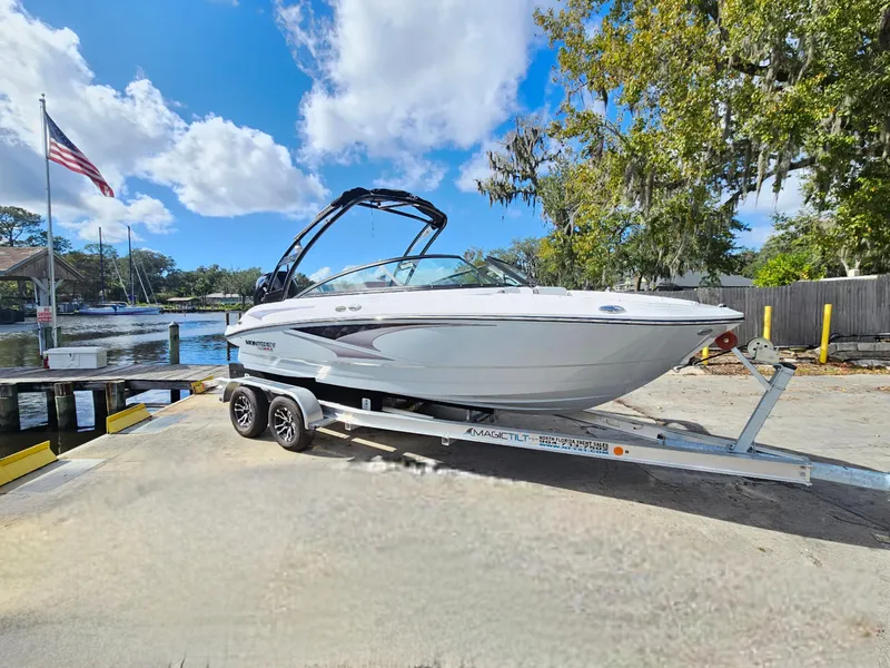 The Image of 2026 Monterey M-205 boat on trailer by a lakeside dock under a blue sky. - 0