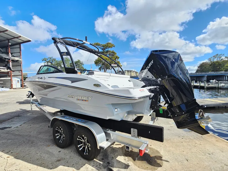 Slide: The Image of 2026 Monterey M-205 boat on trailer, dockside, under blue sky. - 5