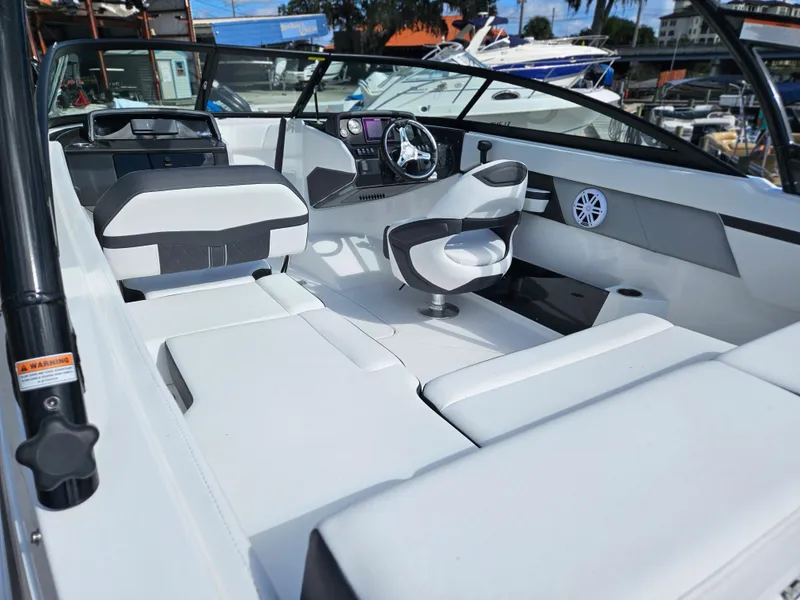 Slide: The Image of Interior of 2026 Monterey M-205 boat, featuring sleek white seating and modern dashboard. - 11