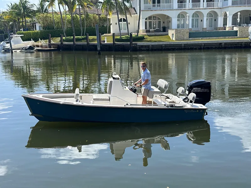 The Image of 2024 Dragonfly 21 Spanish Wells boat on calm water near luxury waterfront homes. - 0