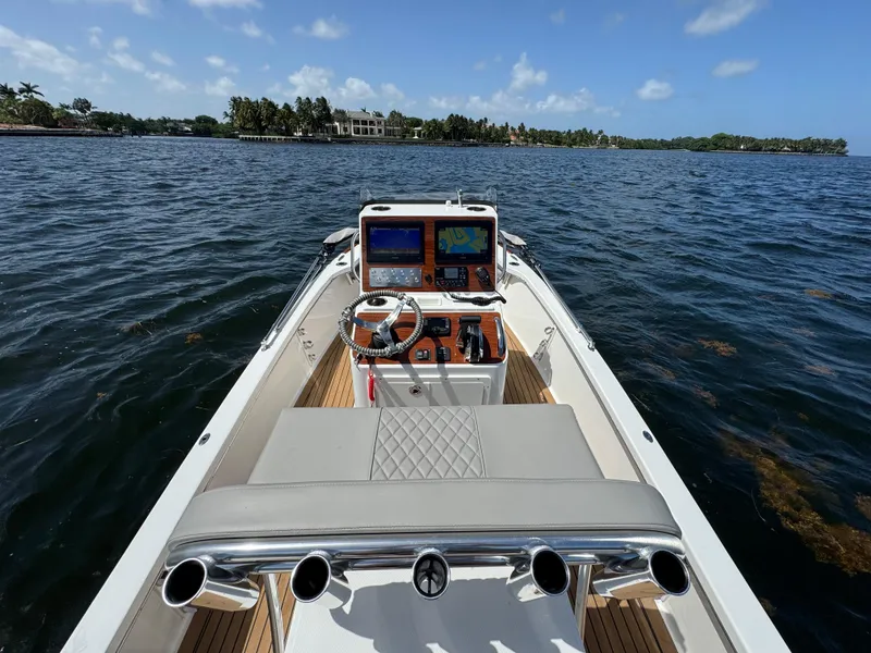 Slide: The Image of 2024 Dragonfly 21 Spanish Wells boat on water, featuring modern dashboard and steering wheel. - 12