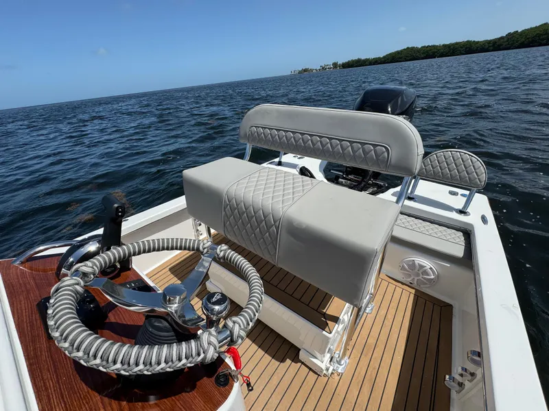 Slide: The Image of 2024 Dragonfly 21 Spanish Wells boat interior with stylish seating and steering wheel on open water. - 13