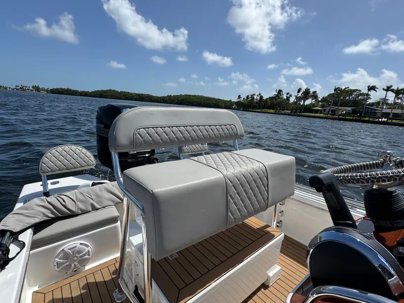 Slide: The Image of 2024 Dragonfly 21 Spanish Wells boat interior with cushioned seating, on a sunny day. - 24