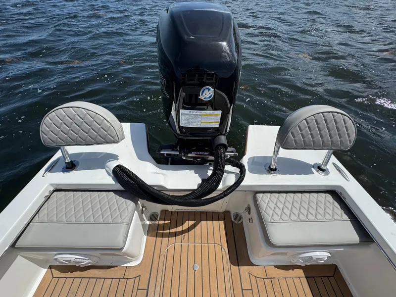Slide: The Image of 2024 Dragonfly 21 Spanish Wells boat with cushioned seating and powerful outboard motor on water. - 26