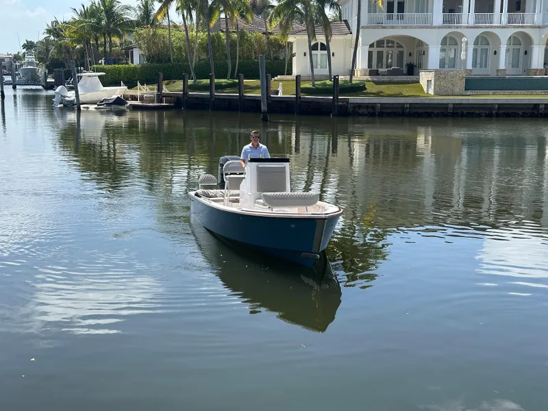 Slide: The Image of 2024 Dragonfly 21 Spanish Wells boat on calm water near luxury waterfront homes. - 3