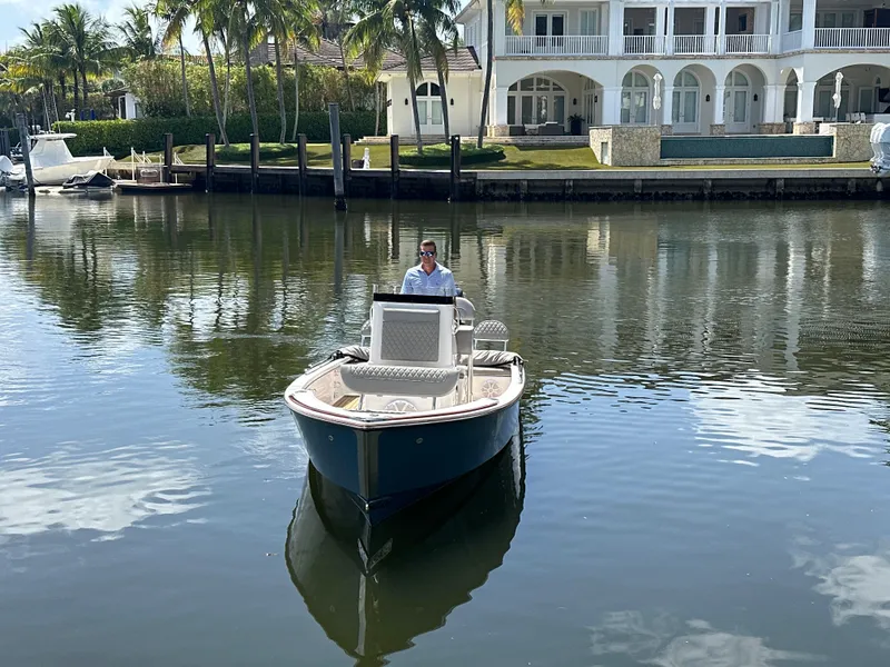 Slide: The Image of 2024 Dragonfly 21 Spanish Wells boat on calm water near luxury waterfront home. - 6
